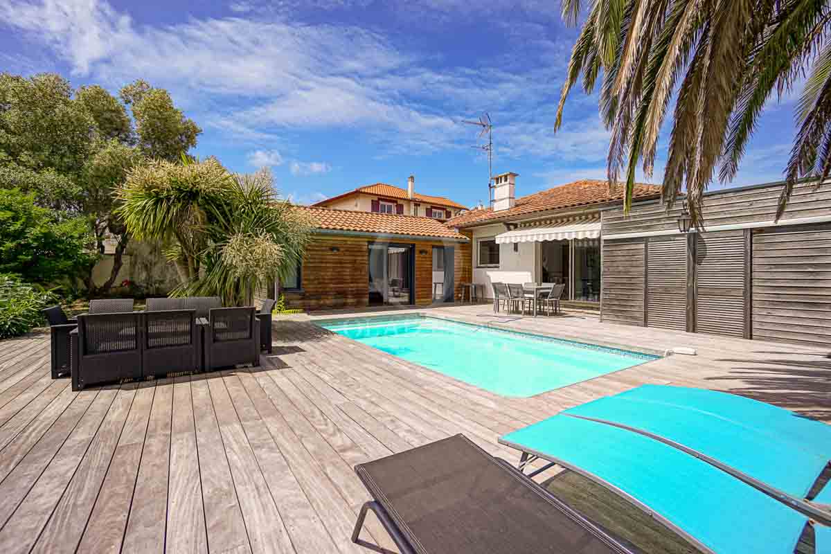 Image de la location de vacances numero 56 situé à Anglet Nichée à Anglet, magnifique maison individuelle de plain-pied avec une surface habitable de 137 mètres carrés. Cette demeure offre un cadre de vie agréable et spacieux. Elle se compose de 4 pièces principales, dont 3 chambres, et 2 salles d'eau.

La maison, entourée d'un terrain de 05 ares 80 centiares, est équipée d'une piscine privée, vous promettant des moments de détente et de plaisir. Profitez d'une grande terrasse, de transats pour vous prélasser au soleil, d'une plancha pour de savoureuses grillades, ainsi que d'une salle à manger et d'un salon extérieur pour des moments conviviaux.

À l'intérieur, une cuisine ouverte équipée s'offre à vous, ainsi qu'une buanderie avec point d'eau. Les équipements de la maison sont complétés par un WC indépendant. Avec une ambiance extérieure en bois chaleureuse, cette maison offre un cadre de vacances idyllique.  